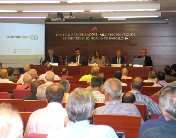 Reunió del professionals en la sala amb la pantalla i el logo de CONSTRUSENIOR 2011